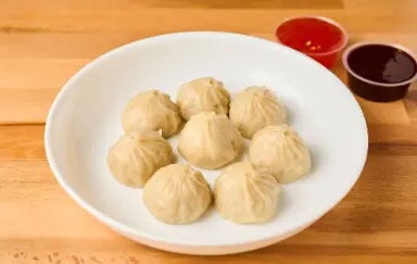 Steamed momos with dipping sauces
